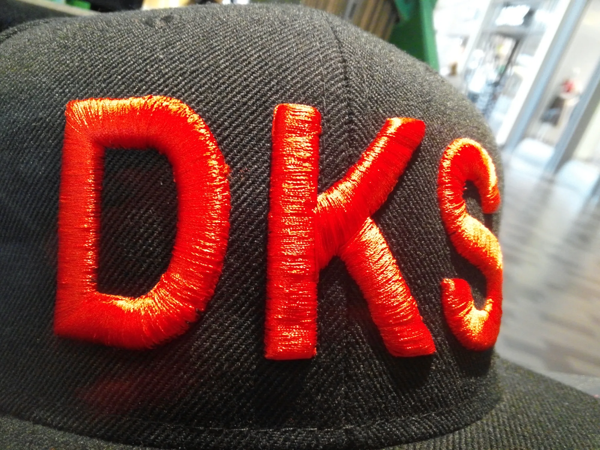 Red 3D embroidered lettering on a black cap, stitched at MSE Embroidery